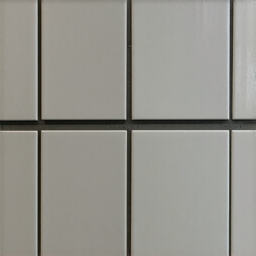Close up of a professional mitered tile corner joint in a shower niche showing a seamless finish without metal strips.